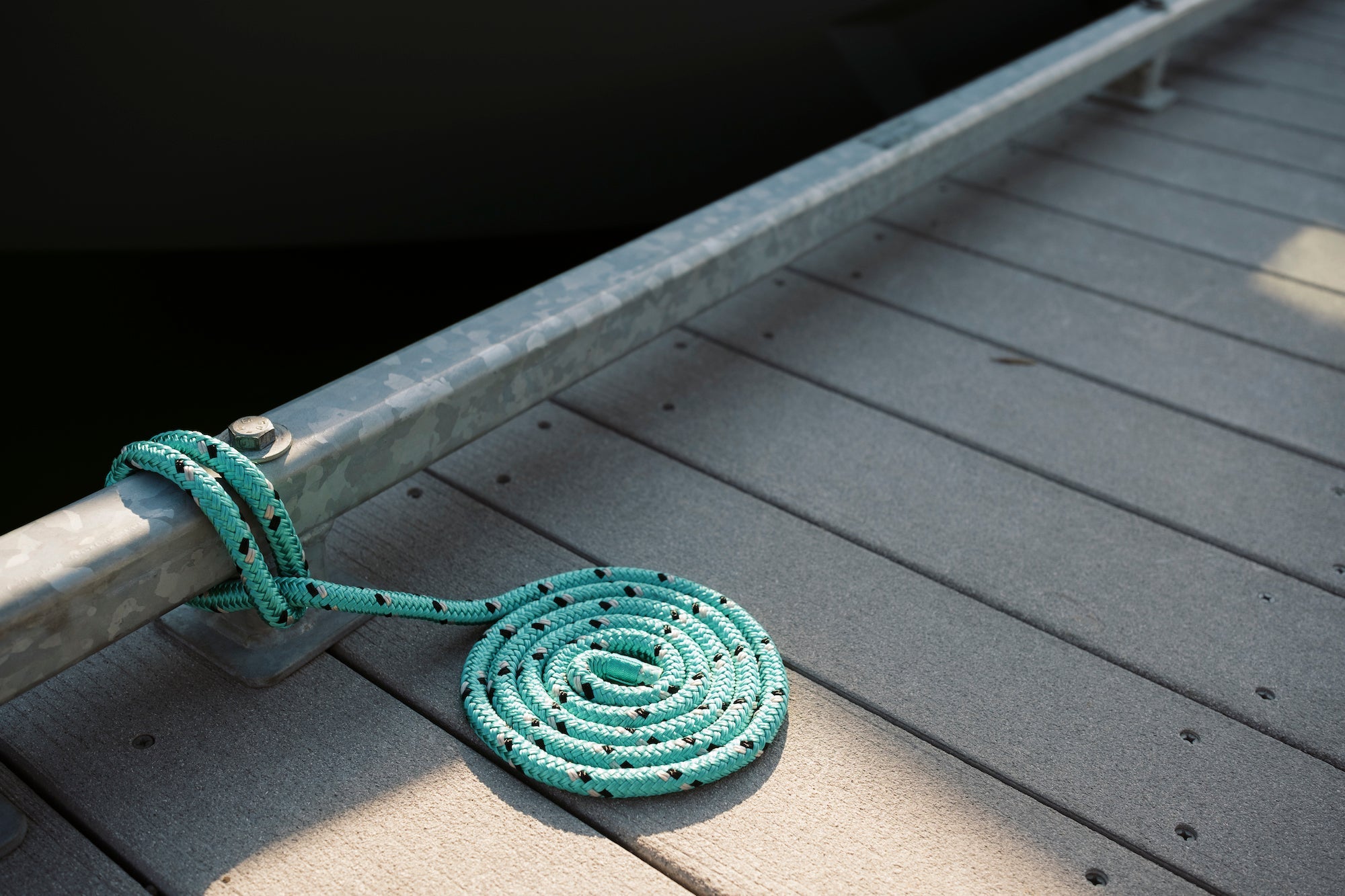 Green Dock-Line from Seipel Marina coiled on a light brown marine dock.