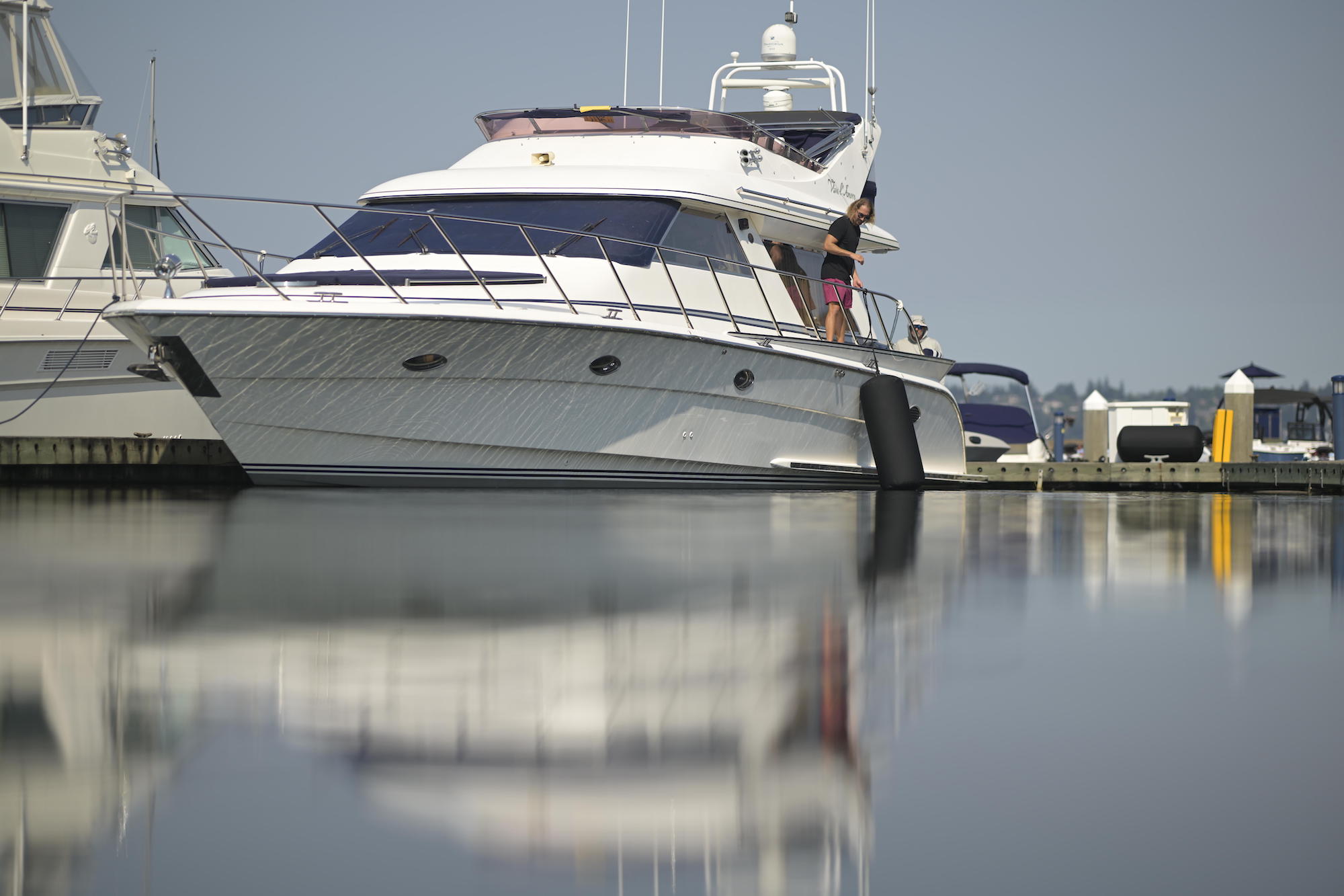 A yacht tied to a marina in calm water, Seipel Marine Fenders are hanging off the side to protect the Yacht.