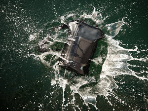 Top view of Backpack floating in water, demonstrating waterproof construction and sealed zipper.