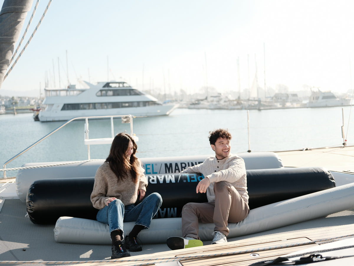 Two people seated on Seipel Marine inflatable dock bumpers arranged as deck seating on a boat.