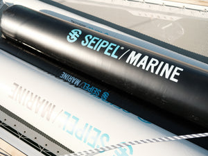 Close-up of black inflatable dock fenders with Seipel Marine logo resting on a boat deck.