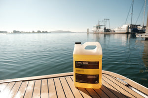 Seipel Marine EVA foam cleaner refill jug placed on a teak boat deck with marina in the background.